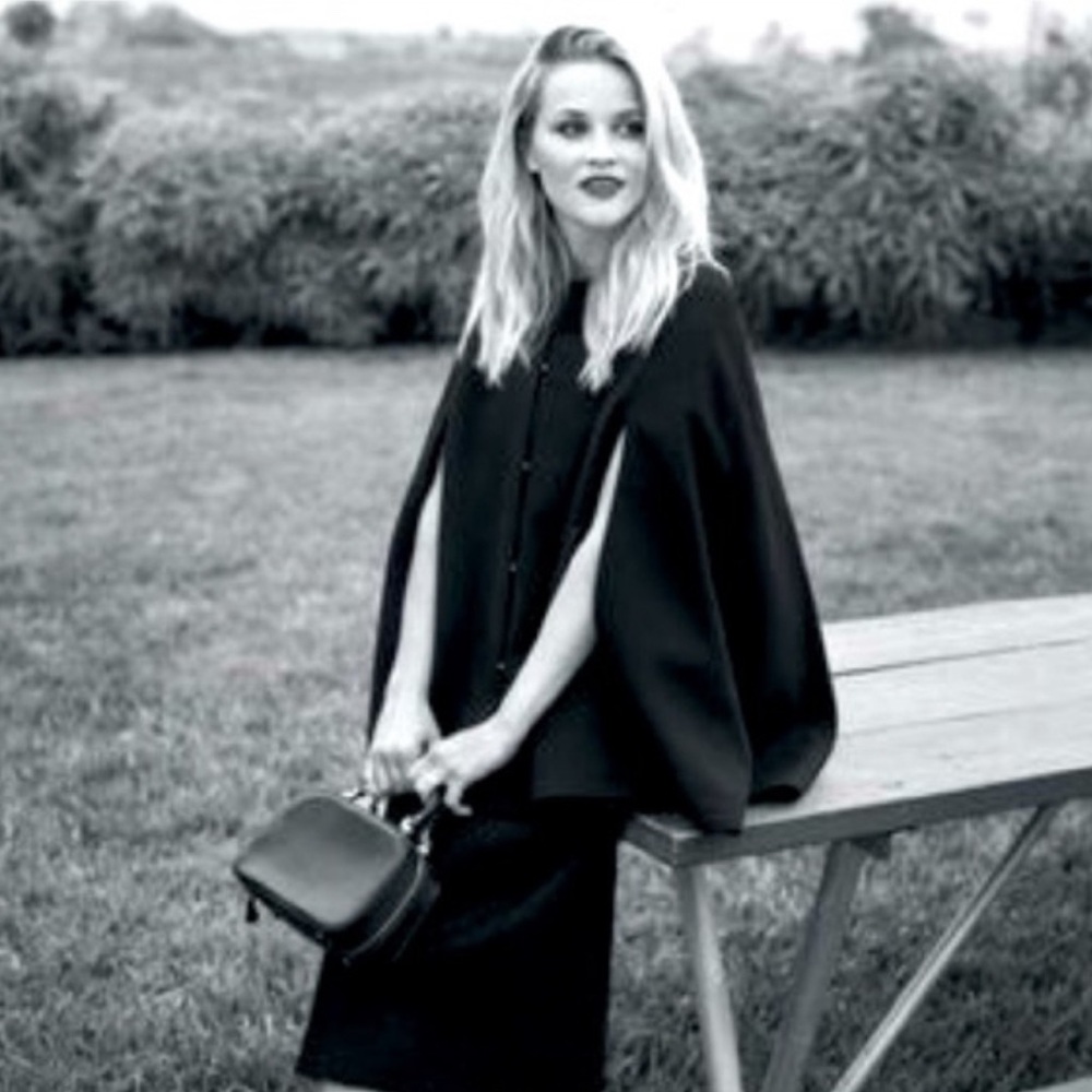 Draper James black cape with leather detailing at pockets and neckline.